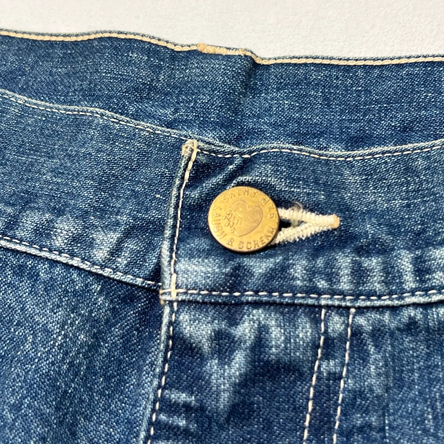 SAINT Mxxxxxx DOUBLE KNEE SHORTS/BLU Knee patches splashed with ink and water-splashed denim shorts. Denim blue S-XL. Custom-woven and dyed denim fabric with clear texture. Heavy-wash water-fading treatment to create local mottled fading/hole effects. Artificial distressing to simulate natural wearing marks. VINTAGE sense. Original consistent damage treatment. Hand-splashed ink and paint. Original consistent wash mark/pocket mark. Double knee patch. Rivet reinforcement. Improve functionality while enhancing design